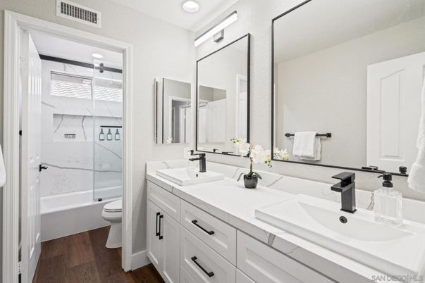 Bathroom, Dual Sink Vanities, Glass Shower, Interior, Marble Walls, Recessed Lighting, Wood Texture Flooring