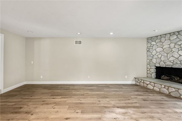 Empty room, Fireplace, Interior, Recessed Lighting, Stone Walls, Wood Texture Flooring
