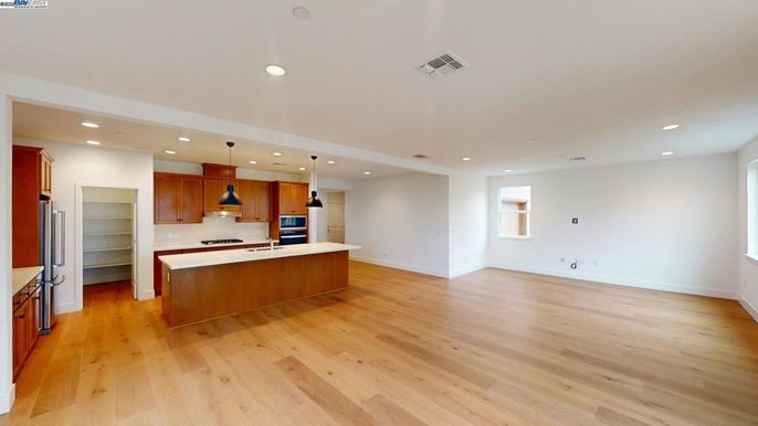Empty room, Interior, Kitchen, Pendant Lights, Recessed Lighting, Stainless Steel Appliances, Wood Texture Flooring