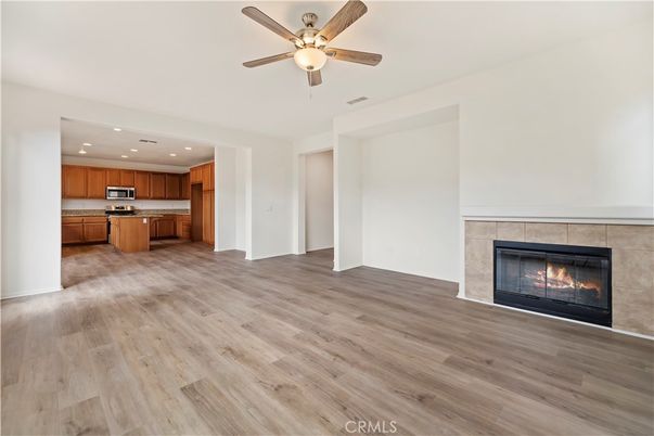 Empty room, Fireplace, Interior, Kitchen, Recessed Lighting, Stainless Steel Appliances, Wood Texture Flooring
