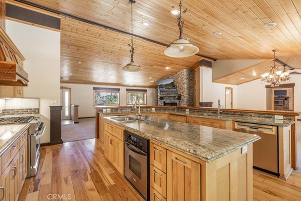 Chandelier, Fireplace, Interior, Kitchen, Pendant Lights, Recessed Lighting, Stainless Steel Appliances, Wooden Ceilings, Wood Texture Flooring