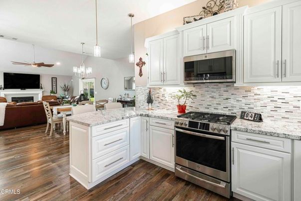Chandelier, Dining room, Fireplace, Interior, Kitchen, Living room, Pendant Lights, Stainless Steel Appliances, Wood Texture Flooring
