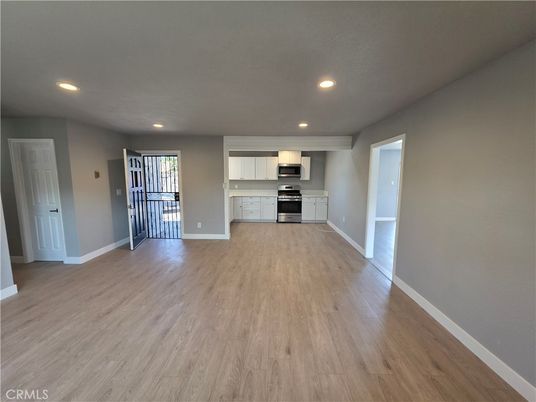 Empty room, Interior, Kitchen, Recessed Lighting, Stainless Steel Appliances, Wood Texture Flooring
