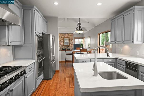 Dining room, Fireplace, Interior, Kitchen, Pendant Lights, Recessed Lighting, Stainless Steel Appliances, Stone Walls, Wood Texture Flooring