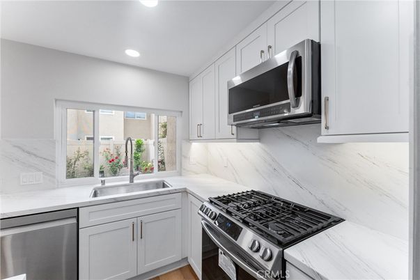 Interior, Kitchen, Marble Walls, Recessed Lighting, Stainless Steel Appliances, Wood Texture Flooring