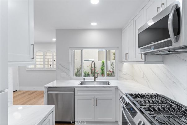 Interior, Kitchen, Marble Walls, Recessed Lighting, Stainless Steel Appliances, Wood Texture Flooring