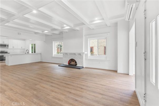 Empty room, Fireplace, Interior, Kitchen, Recessed Lighting, Stainless Steel Appliances, Wood Texture Flooring