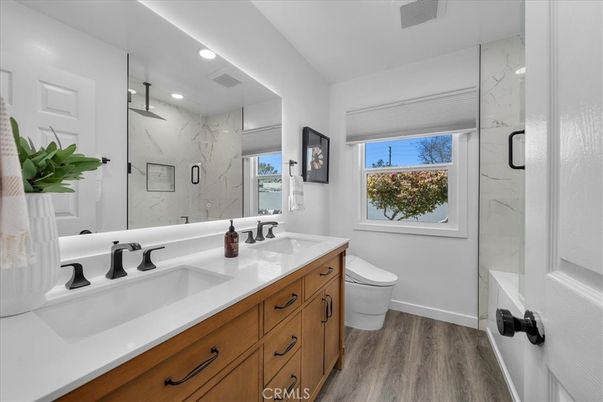 Bathroom, Dual Sink Vanities, Glass Shower, Interior, Marble Walls, Recessed Lighting, Wood Texture Flooring