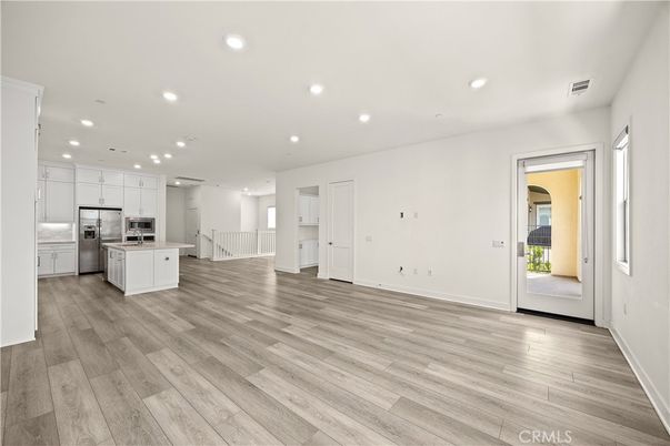 Empty room, Interior, Kitchen, Recessed Lighting, Stainless Steel Appliances, Wood Texture Flooring