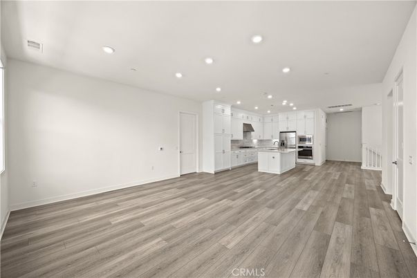 Empty room, Interior, Kitchen, Recessed Lighting, Stainless Steel Appliances, Wood Texture Flooring