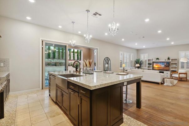 Chandelier, Fireplace, Interior, Kitchen, Living room, Pendant Lights, Recessed Lighting, Stainless Steel Appliances, Wood Texture Flooring
