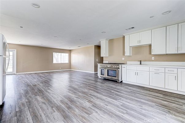 Empty room, Interior, Kitchen, Recessed Lighting, Stainless Steel Appliances, Wood Texture Flooring