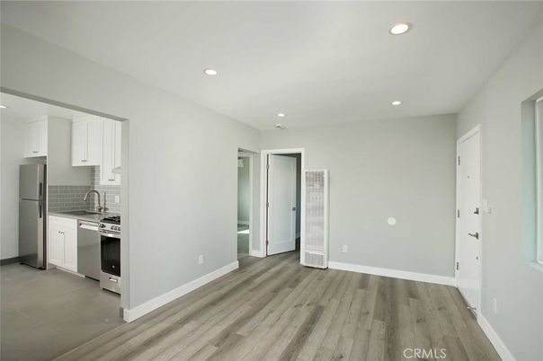 Empty room, Interior, Kitchen, Recessed Lighting, Stainless Steel Appliances, Wood Texture Flooring
