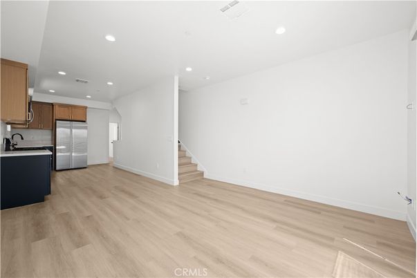 Empty room, Interior, Kitchen, Recessed Lighting, Stainless Steel Appliances, Wood Texture Flooring