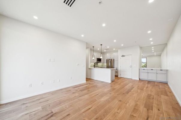 Empty room, Interior, Kitchen, Pendant Lights, Recessed Lighting, Stainless Steel Appliances, Wood Texture Flooring