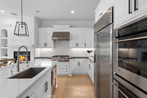 Fireplace, Interior, Kitchen, Pendant Lights, Recessed Lighting, Stainless Steel Appliances, Stone Walls, Wood Texture Flooring