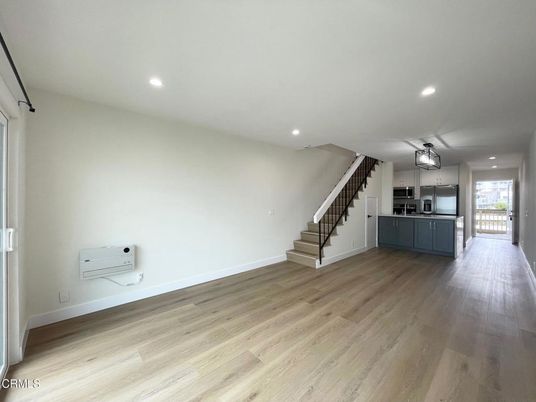 Empty room, Interior, Kitchen, Recessed Lighting, Stainless Steel Appliances, Wood Texture Flooring