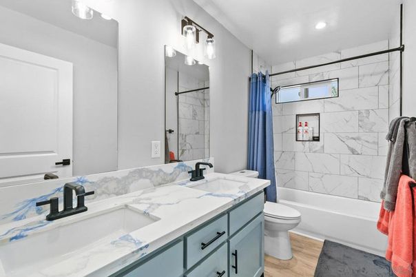 Bathroom, Dual Sink Vanities, Interior, Marble Walls, Recessed Lighting, Wood Texture Flooring