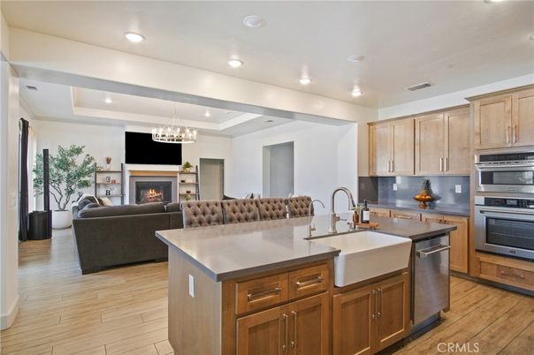 Chandelier, Fireplace, Interior, Kitchen, Living room, Pendant Lights, Recessed Lighting, Stainless Steel Appliances, Wood Texture Flooring