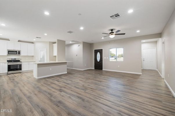 Empty room, Interior, Kitchen, Recessed Lighting, Stainless Steel Appliances, Wood Texture Flooring