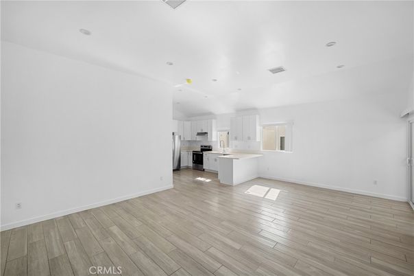 Empty room, Interior, Kitchen, Recessed Lighting, Stainless Steel Appliances, Wood Texture Flooring