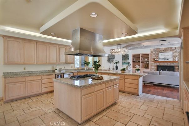 Chandelier, Fireplace, Interior, Kitchen, Living room, Recessed Lighting, Stainless Steel Appliances, Stone Walls, Wood Texture Flooring