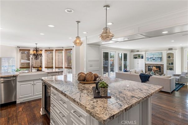 Chandelier, Fireplace, Interior, Kitchen, Living room, Pendant Lights, Recessed Lighting, Stainless Steel Appliances, Wood Texture Flooring