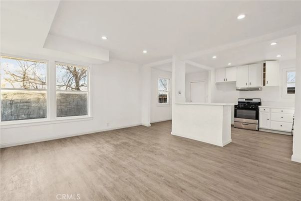 Empty room, Interior, Kitchen, Recessed Lighting, Stainless Steel Appliances, Wood Texture Flooring