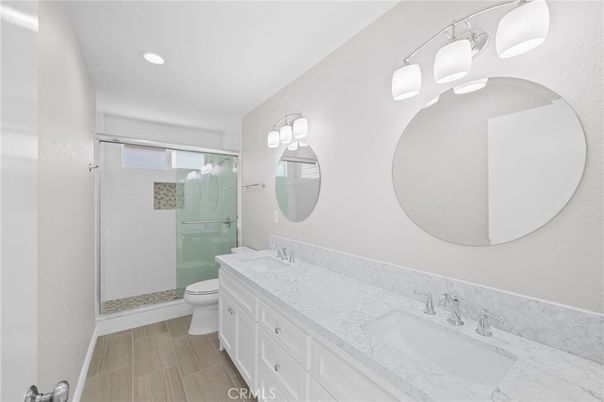 Bathroom, Dual Sink Vanities, Glass Shower, Interior, Recessed Lighting, Wood Texture Flooring