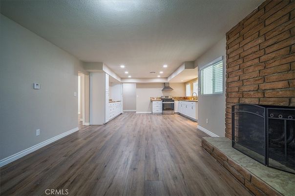 Empty room, Fireplace, Interior, Kitchen, Recessed Lighting, Stone Walls, Wood Texture Flooring