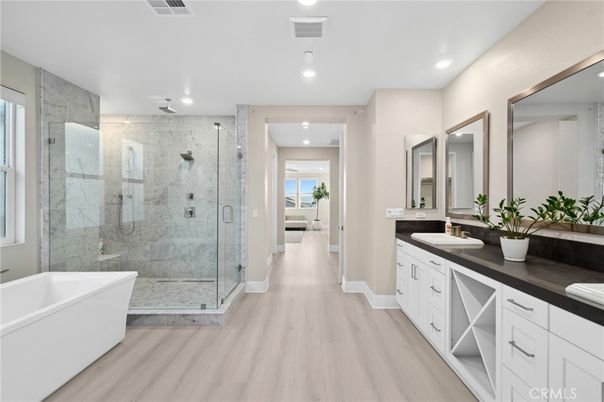 Bathroom, Dual Sink Vanities, Free Standing Baths, Glass Shower, Interior, Marble Walls, Recessed Lighting, Wood Texture Flooring