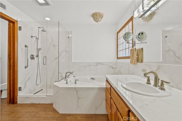 Bathroom, Dual Sink Vanities, Glass Shower, Interior, Marble Walls, Recessed Lighting, Wood Texture Flooring