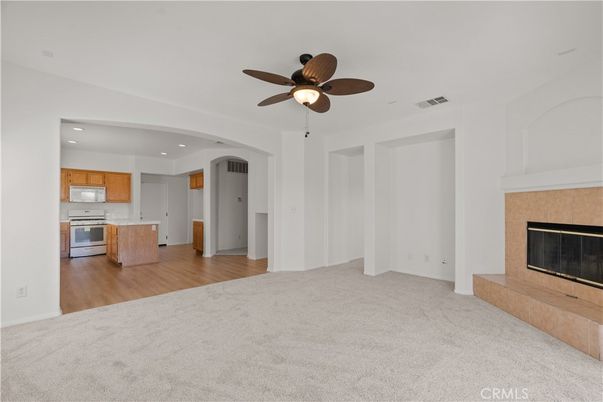Empty room, Fireplace, Interior, Kitchen, Recessed Lighting, Stainless Steel Appliances, Wood Texture Flooring