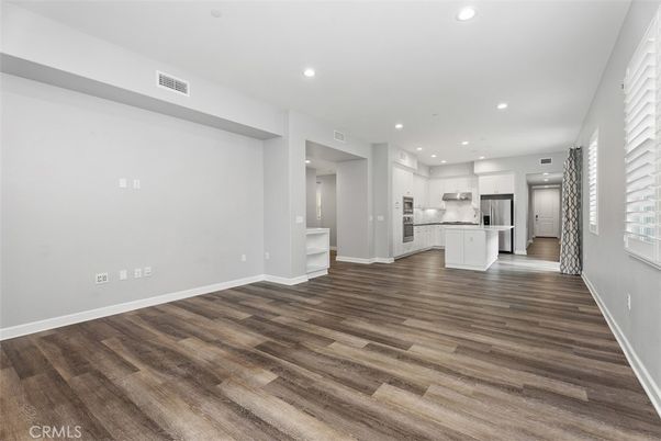 Empty room, Interior, Kitchen, Recessed Lighting, Stainless Steel Appliances, Wood Texture Flooring