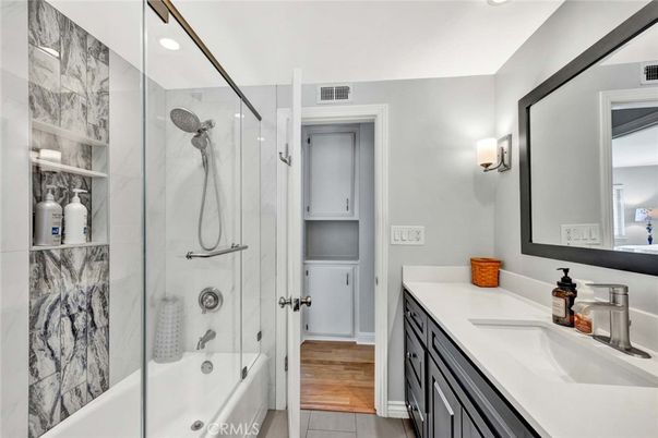 Bathroom, Dual Sink Vanities, Glass Shower, Interior, Marble Walls, Recessed Lighting, Wood Texture Flooring
