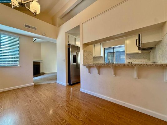 Empty room, Fireplace, Interior, Kitchen, Stainless Steel Appliances, Wood Texture Flooring