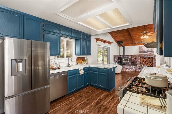 Fireplace, Interior, Kitchen, Stainless Steel Appliances, Tile Countertops, Wooden Ceilings, Wood Texture Flooring