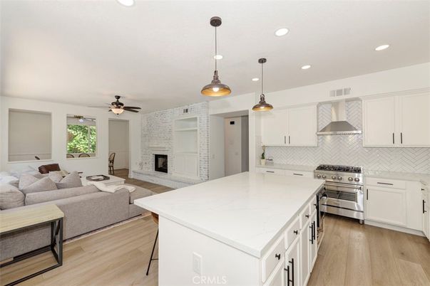Fireplace, Interior, Kitchen, Living room, Pendant Lights, Recessed Lighting, Stainless Steel Appliances, Stone Walls, Wood Texture Flooring