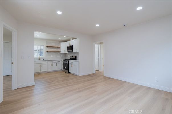 Empty room, Interior, Kitchen, Recessed Lighting, Stainless Steel Appliances, Wood Texture Flooring