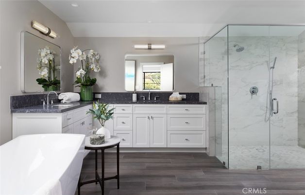 Bathroom, Dual Sink Vanities, Free Standing Baths, Glass Shower, Interior, Marble Walls, Recessed Lighting, Wood Texture Flooring