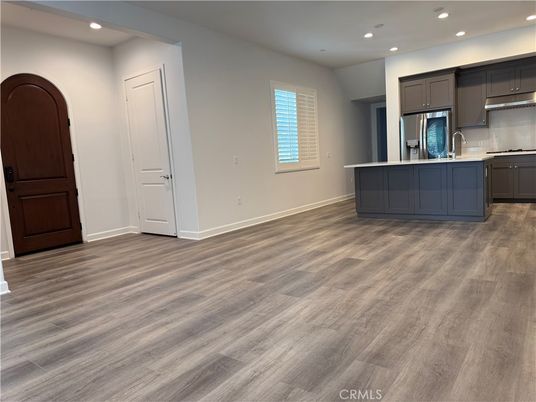 Empty room, Interior, Kitchen, Recessed Lighting, Stainless Steel Appliances, Wood Texture Flooring