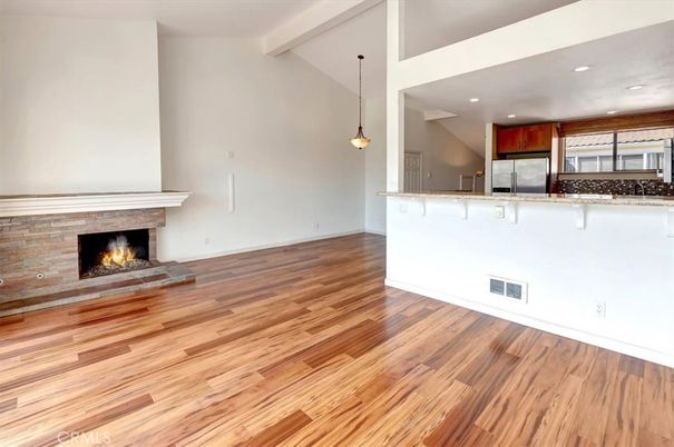 Empty room, Fireplace, Interior, Kitchen, Pendant Lights, Recessed Lighting, Stainless Steel Appliances, Wood Texture Flooring