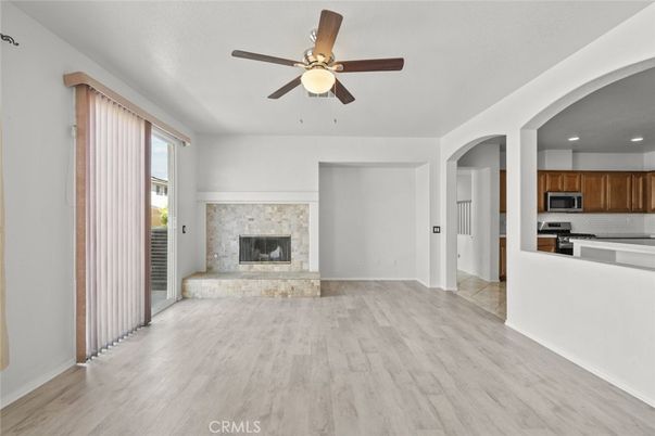 Empty room, Fireplace, Interior, Kitchen, Recessed Lighting, Stainless Steel Appliances, Wood Texture Flooring