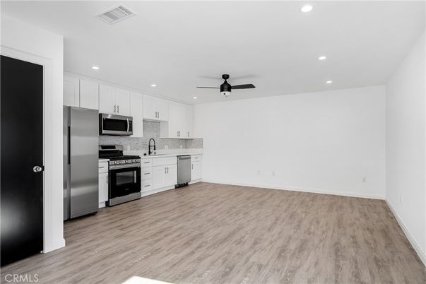 Empty room, Interior, Kitchen, Recessed Lighting, Stainless Steel Appliances, Wood Texture Flooring