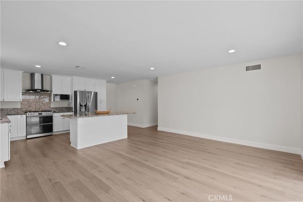Empty room, Interior, Kitchen, Recessed Lighting, Stainless Steel Appliances, Wood Texture Flooring