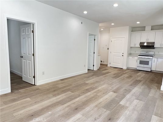 Empty room, Interior, Kitchen, Recessed Lighting, Stainless Steel Appliances, Wood Texture Flooring