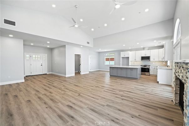 Empty room, Fireplace, Interior, Kitchen, Recessed Lighting, Stainless Steel Appliances, Wood Texture Flooring