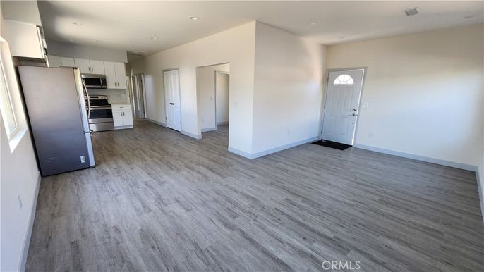 Empty room, Interior, Kitchen, Recessed Lighting, Stainless Steel Appliances, Wood Texture Flooring