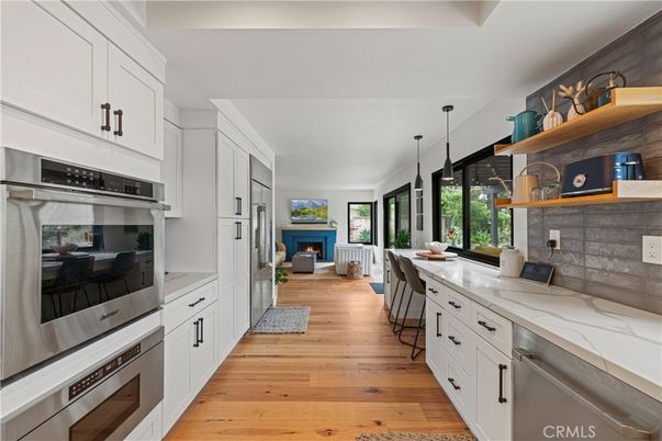 Dining room, Fireplace, Interior, Kitchen, Pendant Lights, Stainless Steel Appliances, Wood Texture Flooring