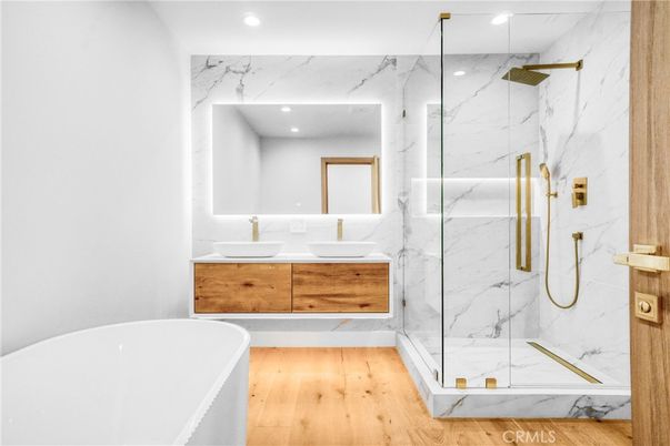 Bathroom, Dual Sink Vanities, Free Standing Baths, Glass Shower, Interior, Marble Walls, Recessed Lighting, Wood Texture Flooring